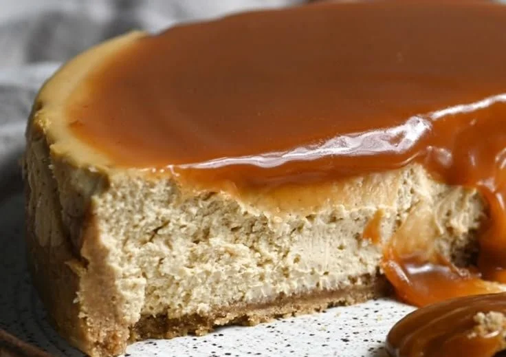 Delicious slice of Apple Cider Cheesecake topped with whipped cream and an apple garnish.