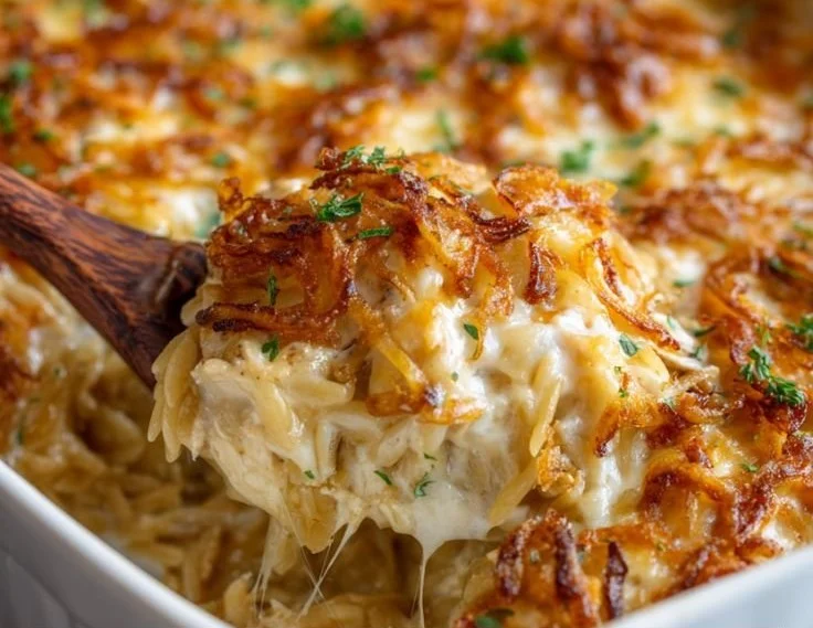 French Onion Chicken Orzo Casserole topped with melted cheese and herbs