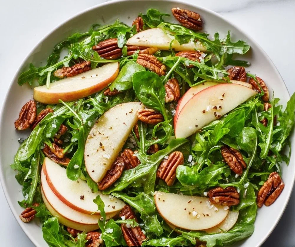 Delicious Apple Arugula Salad topped with Maple Pecans in a bowl.