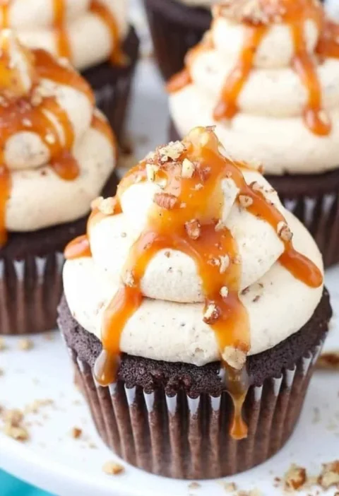Delicious Chocolate Turtle Cupcakes topped with caramel and pecans.
