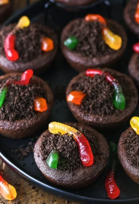 Delicious dirt cups cookies displayed on a plate with chocolate and cookie crumbles.