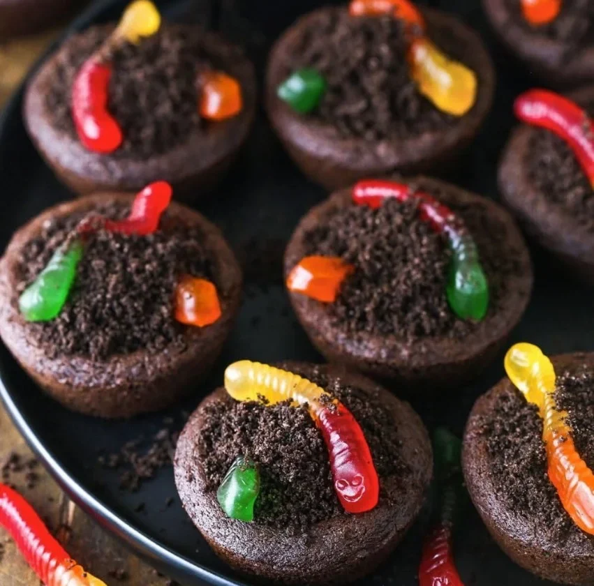 Delicious dirt cups cookies displayed on a plate with chocolate and cookie crumbles.