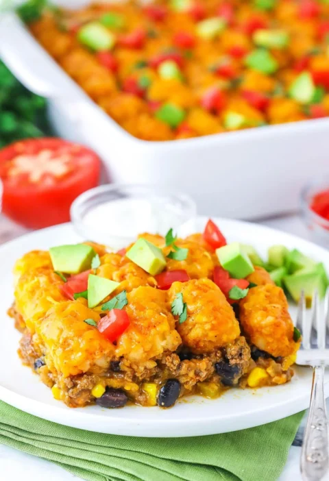 Delicious taco tater tot casserole baked to perfection with toppings.