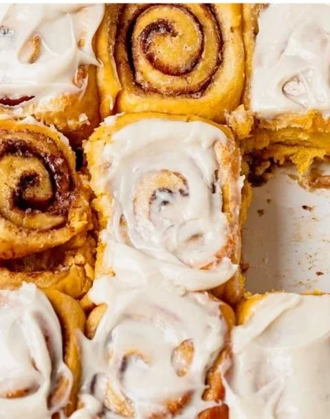 Freshly baked pumpkin cinnamon rolls drizzled with glaze