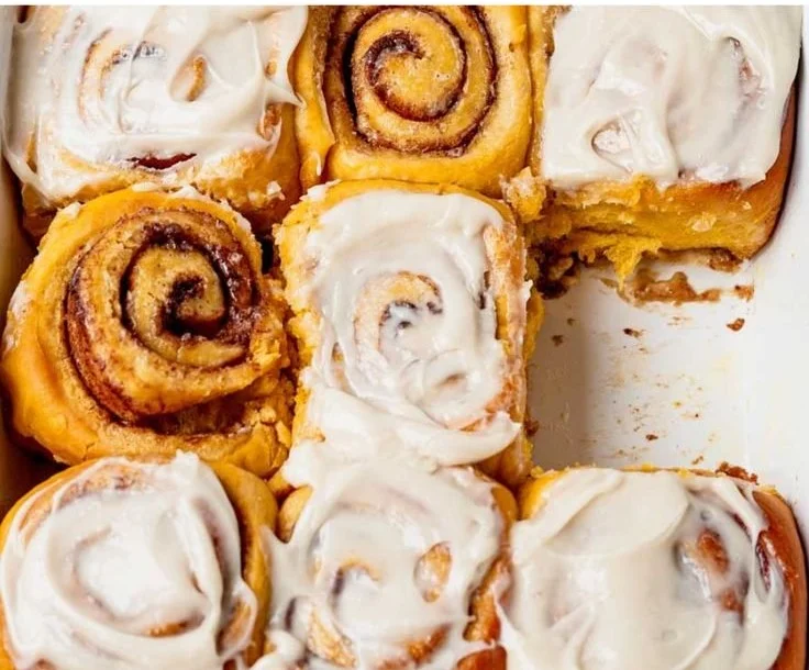 Freshly baked pumpkin cinnamon rolls drizzled with glaze