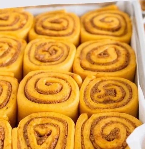Delicious homemade pumpkin cinnamon rolls drizzled with icing.