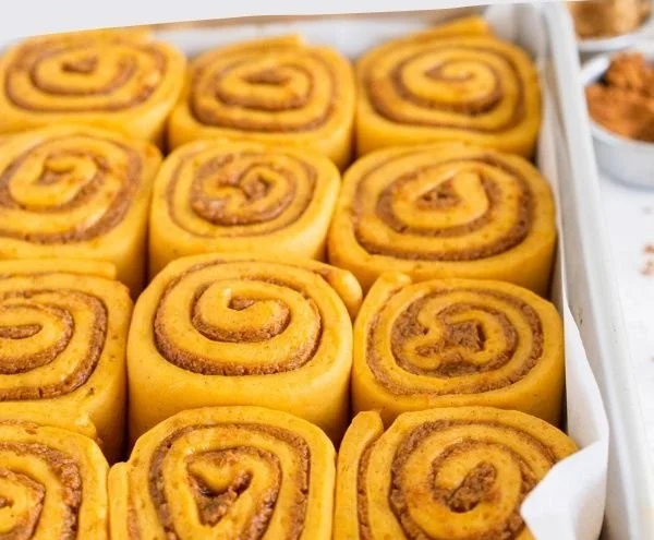Delicious homemade pumpkin cinnamon rolls drizzled with icing.