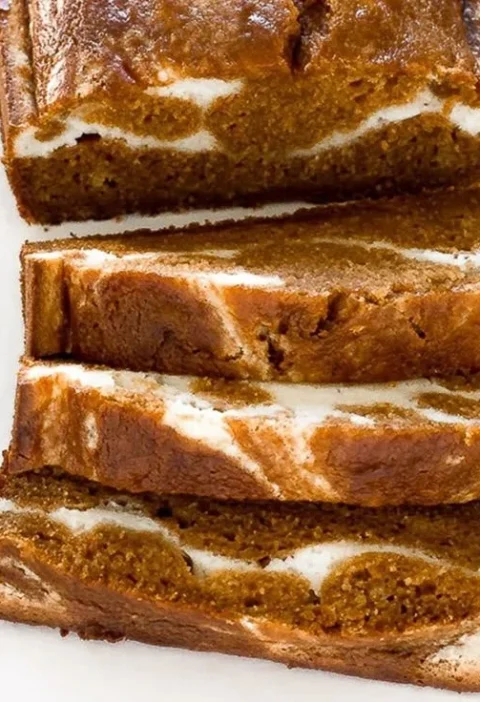 Deliciously baked Pumpkin Cream Cheese Swirl Bread topped with cream cheese frosting.