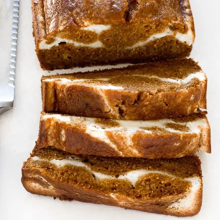 Deliciously baked Pumpkin Cream Cheese Swirl Bread topped with cream cheese frosting.