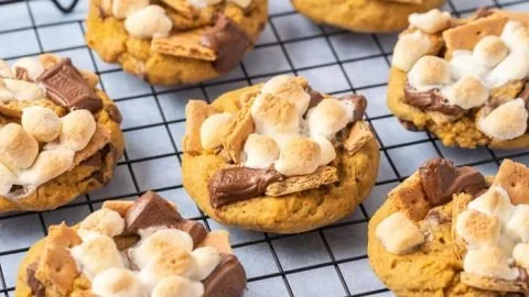Delicious Pumpkin S'mores Cookies on a rustic wooden table.