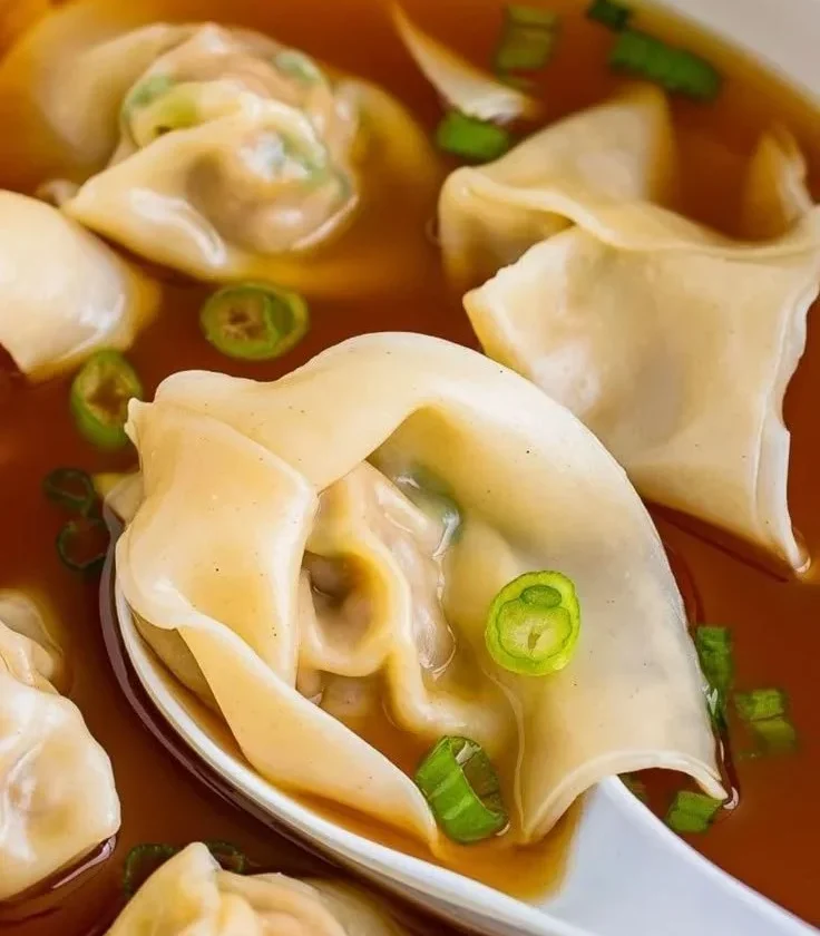 Bowl of delicious wonton soup with dumplings and vegetables