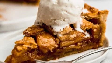 Delicious Apple Pie à la Mode topped with vanilla ice cream on a plate