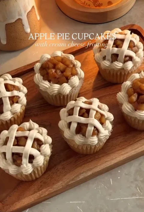 Delicious apple pie cupcakes topped with cinnamon frosting and fresh apple slices.