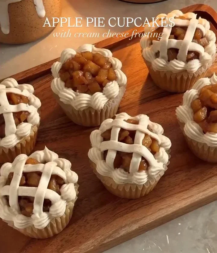 Delicious apple pie cupcakes topped with cinnamon frosting and fresh apple slices.