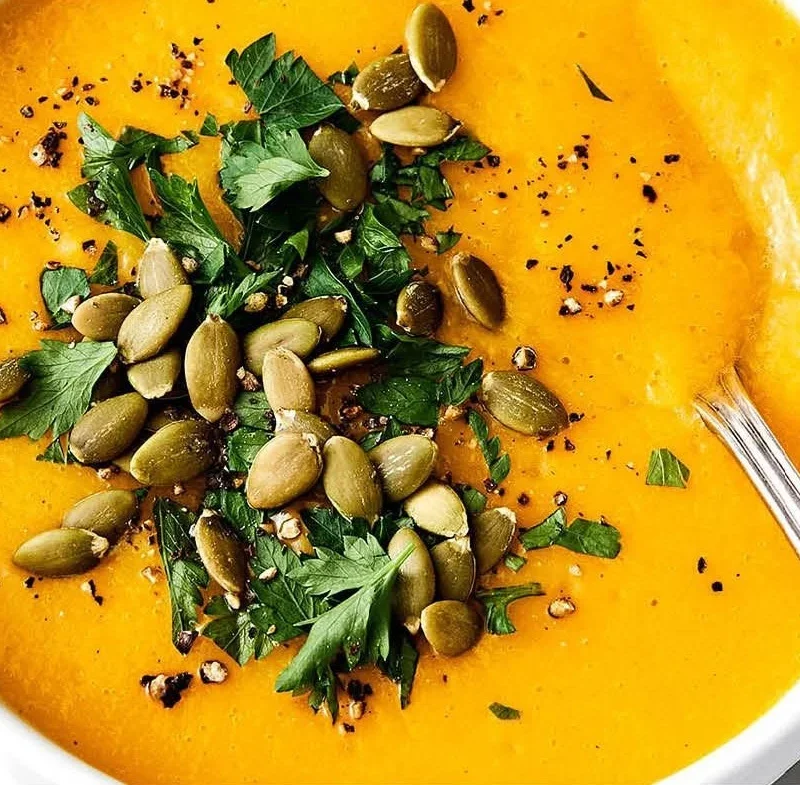 Delicious bowl of homemade butternut squash soup garnished with herbs