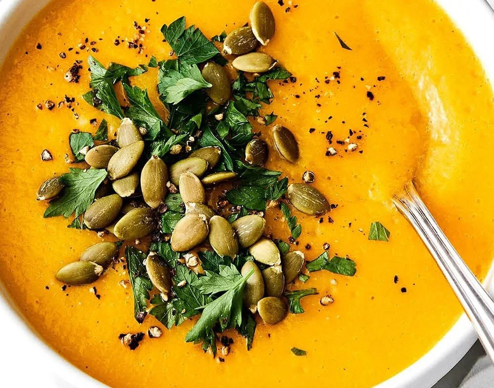 Delicious bowl of homemade butternut squash soup garnished with herbs