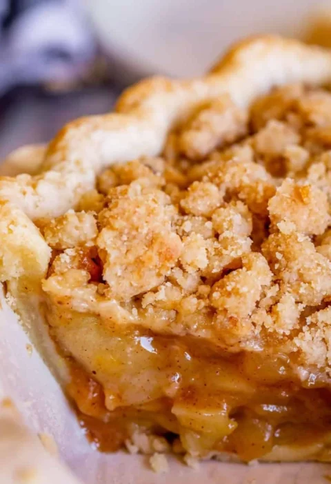 Delicious slice of Dutch apple pie with all-butter crust on a wooden table