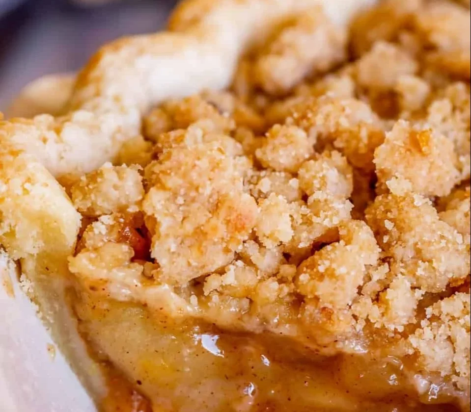 Delicious slice of Dutch apple pie with all-butter crust on a wooden table