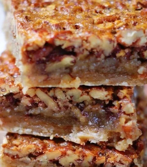 Delicious homemade pecan pie bars on a plate with nuts