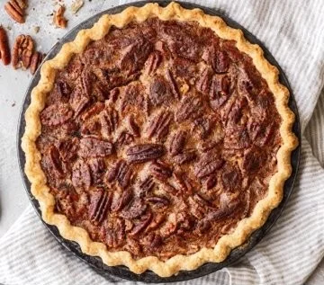 Delicious slice of homemade pecan pie on a rustic wooden table