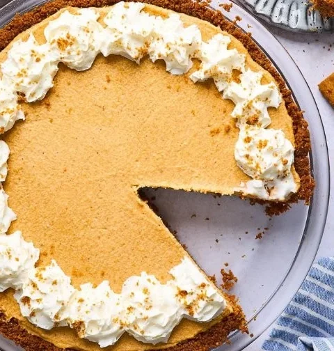 Delicious Biscoff pumpkin pie served on a wooden table decorated for autumn.