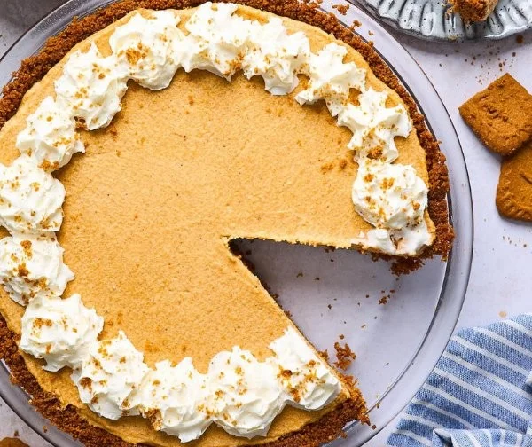 Delicious Biscoff pumpkin pie served on a wooden table decorated for autumn.