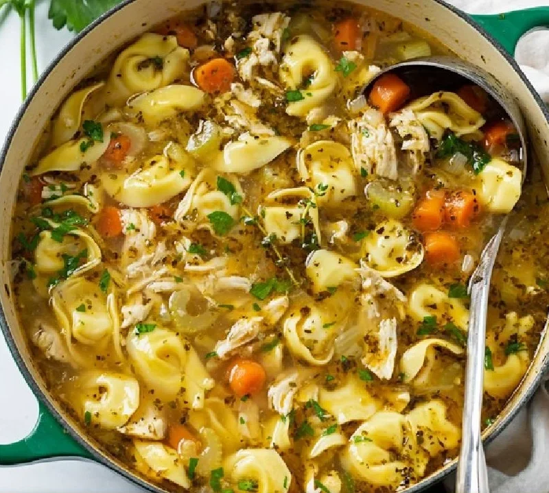 Bowl of Chicken Tortellini Soup with fresh herbs and vegetables