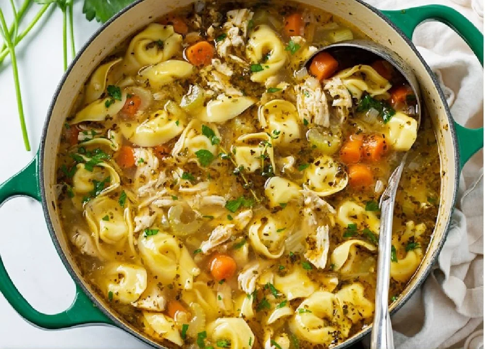Bowl of Chicken Tortellini Soup with fresh herbs and vegetables