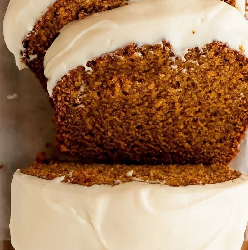 Slice of cream cheese frosted pumpkin bread on a plate