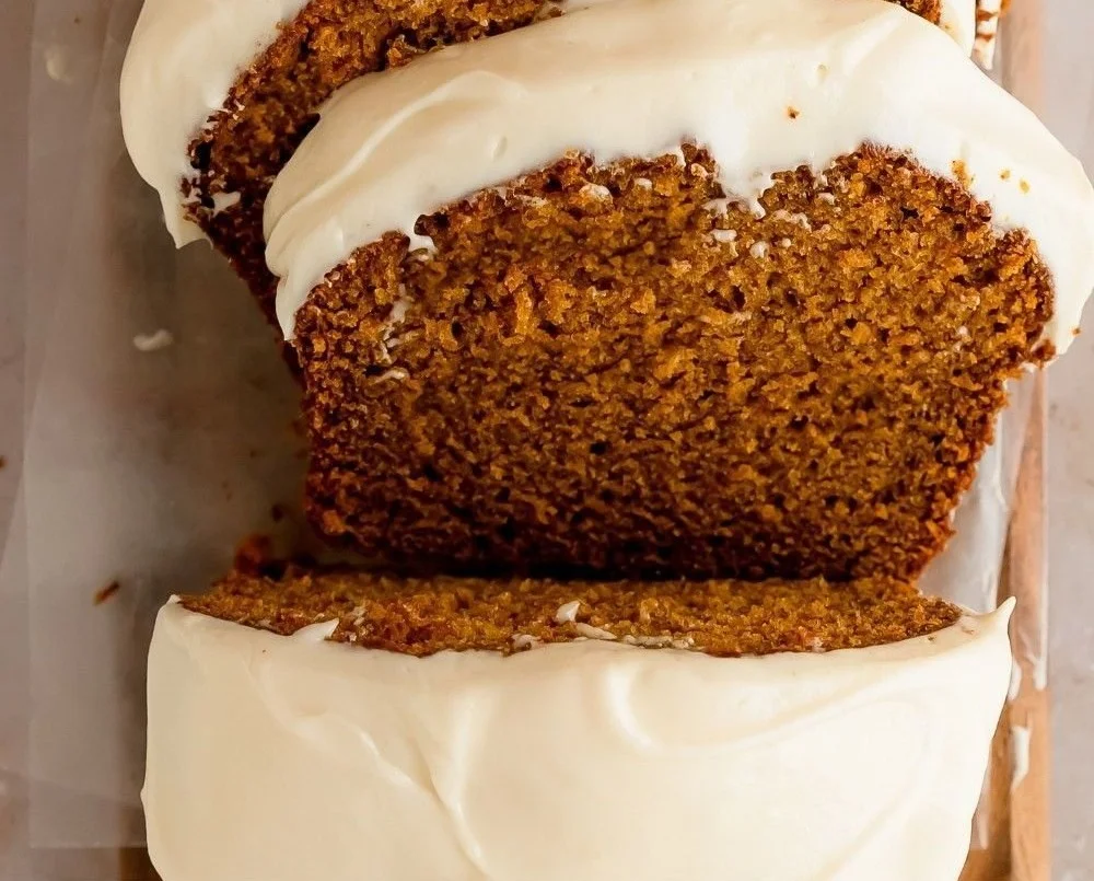 Slice of cream cheese frosted pumpkin bread on a plate