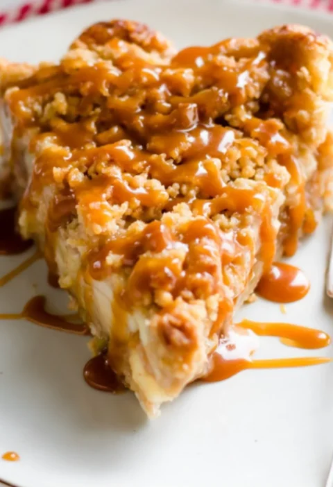 Slice of Dutch caramel apple pie with caramel drizzle
