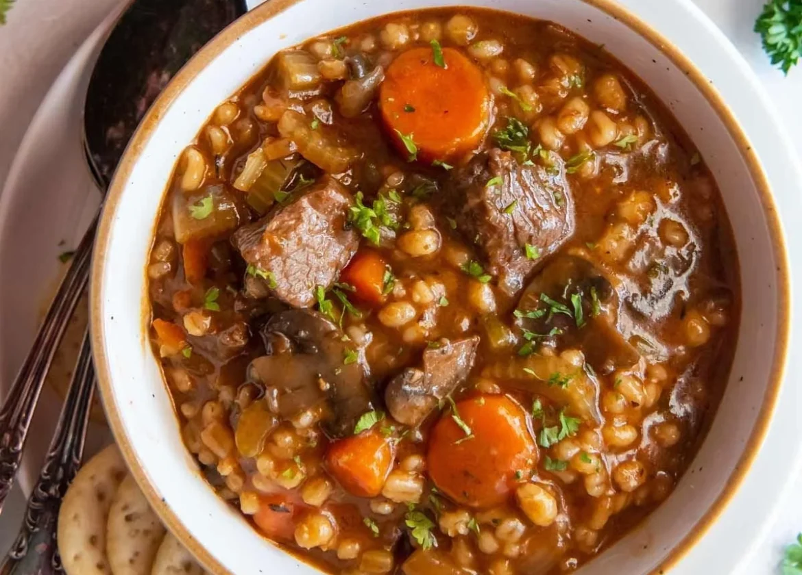 Bowl of easy beef barley soup with vegetables and herbs