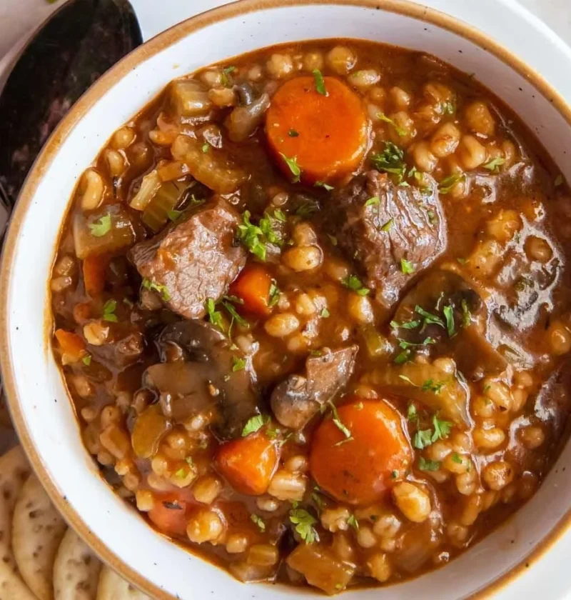 Bowl of easy beef barley soup with vegetables and herbs