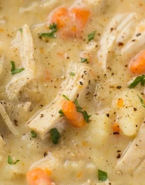 Healthy Chicken Pot Pie Soup in a bowl garnished with herbs