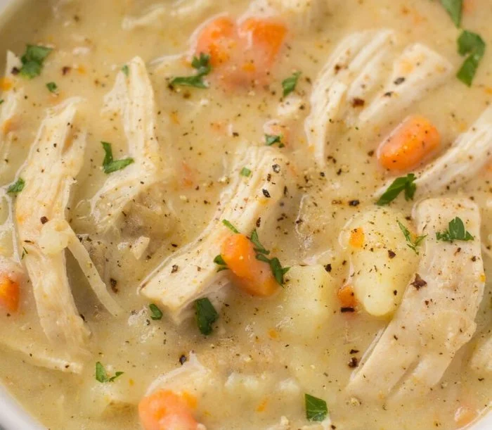 Healthy Chicken Pot Pie Soup in a bowl garnished with herbs