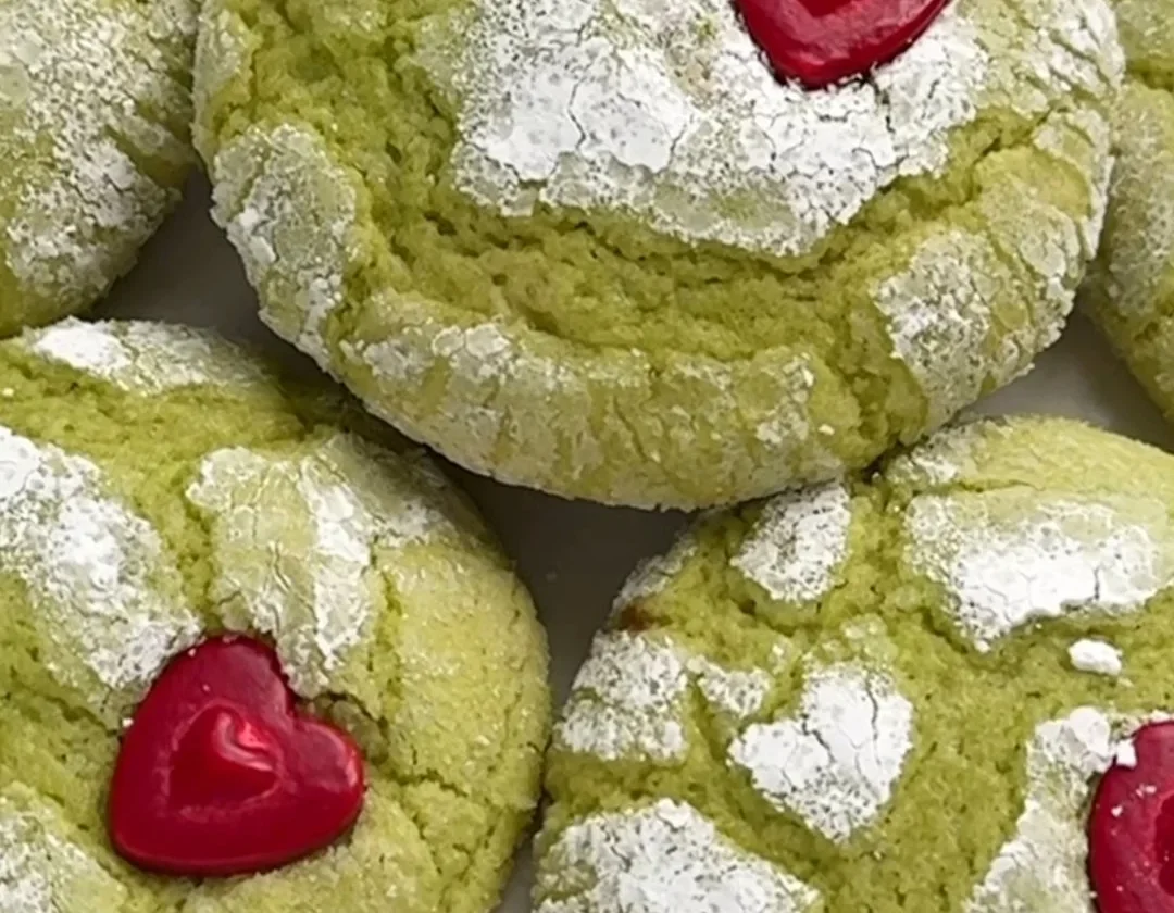 Festive Grinch cookies decorated with green frosting and candy