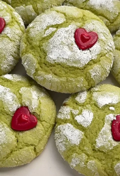 Festive Grinch cookies decorated with green frosting and candy