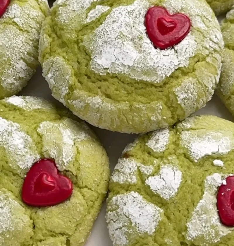 Festive Grinch cookies decorated with green frosting and candy