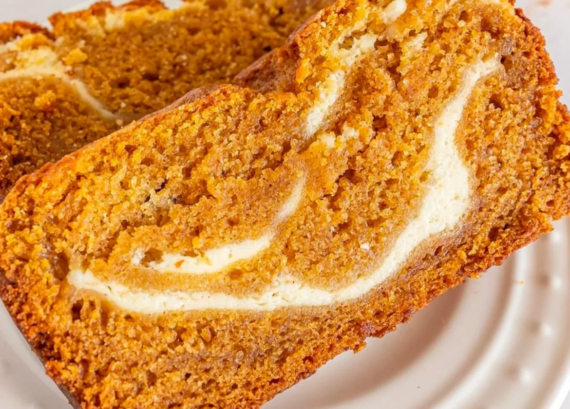 Slice of Joanna Gaines' pumpkin cream cheese bread topped with cream cheese frosting