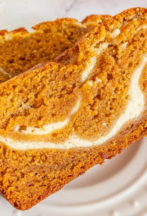 Slice of Joanna Gaines' pumpkin cream cheese bread topped with cream cheese frosting