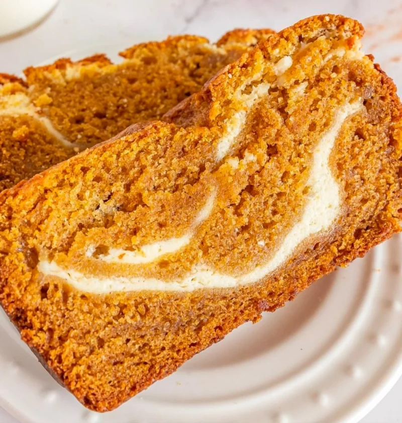 Slice of Joanna Gaines' pumpkin cream cheese bread topped with cream cheese frosting