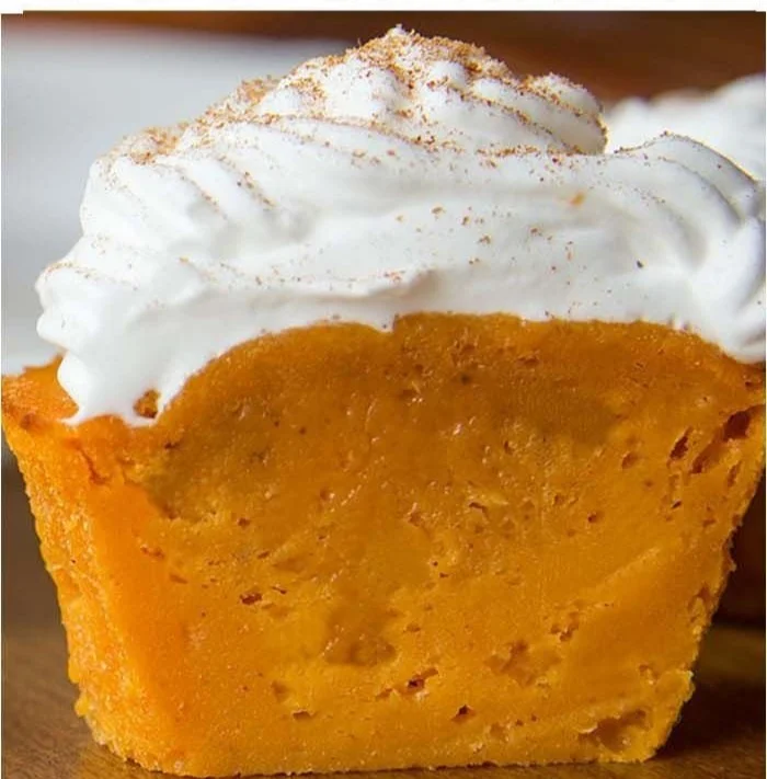 Photo of delicious Impossible Pumpkin Pie Cupcakes topped with whipped cream