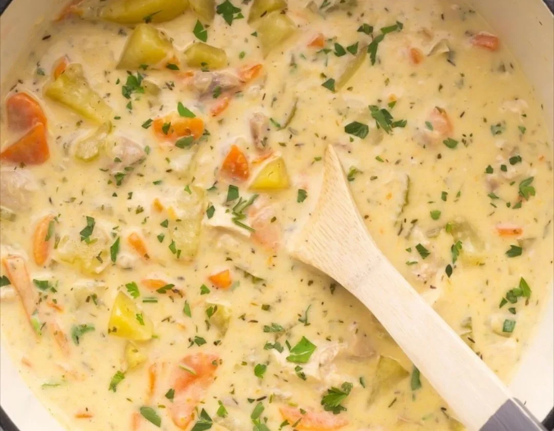 Delicious homemade leftover turkey soup in a bowl garnished with herbs.