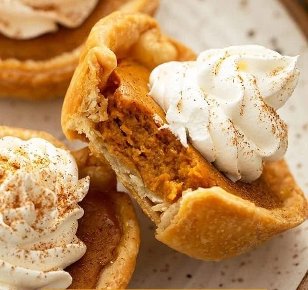 Delicious mini pumpkin pies with whipped cream topping