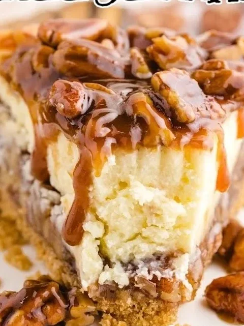 Delicious pecan pie cheesecake topped with pecans and caramel drizzle