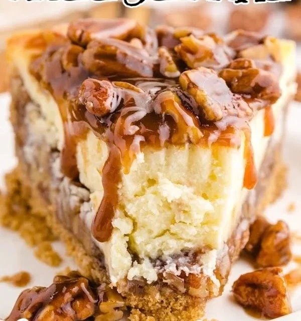 Delicious pecan pie cheesecake topped with pecans and caramel drizzle