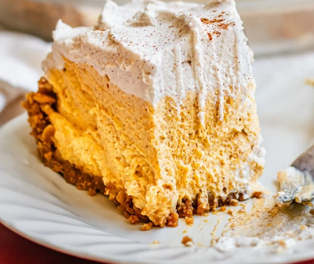 Delicious Pumpkin Mousse Pie topped with whipped cream and autumn spices
