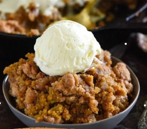 Delicious pumpkin pie crisp dessert served in a bowl, perfect for Thanksgiving.