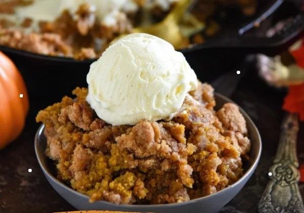 Delicious pumpkin pie crisp dessert served in a bowl, perfect for Thanksgiving.