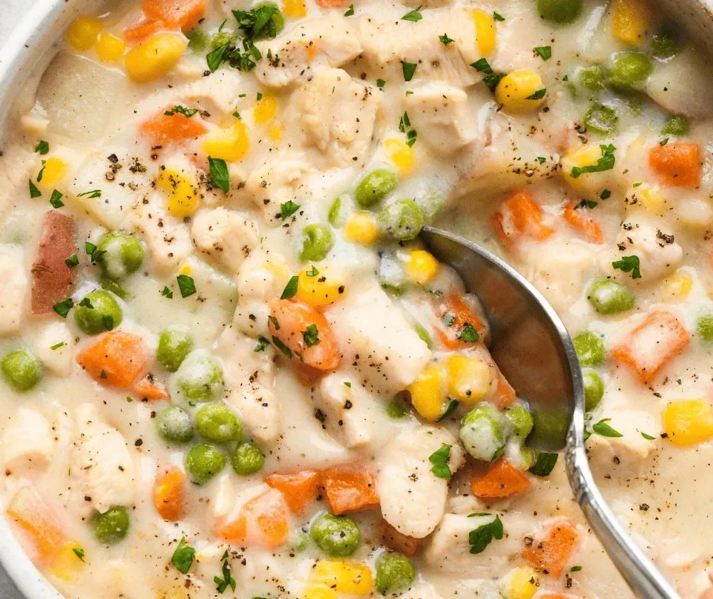 Slow Cooker Chicken Pot Pie Soup topped with fresh herbs in a bowl